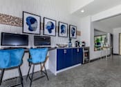 Thumbnail 21 of 63 - a living room with blue chairs and a counter with televisions at The Keller, Texas, 78230