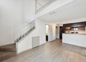 Thumbnail 55 of 60 - the living room and kitchen of an apartment with white walls and wood floors