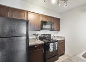Thumbnail 53 of 60 - an apartment kitchen with black appliances and wood cabinets