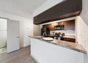 Thumbnail 56 of 60 - a kitchen with a counter top and a refrigerator