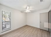 Thumbnail 54 of 60 - an empty living room with a window and a ceiling fan