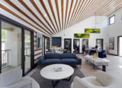 Thumbnail 7 of 60 - Community clubhouse with a blue couch and a white coffee table at Maxwell Townhomes, San Antonio, Texas
