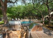 Thumbnail 31 of 47 - Swimming Pool w/ Outdoor Grilling Center at Carmel at Deerfield in San Antonio, TX