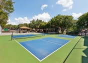 Thumbnail 22 of 47 - a pickleball court with two blue and green tennis courts