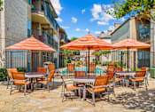 Thumbnail 28 of 40 - A patio with orange chairs and umbrellas.