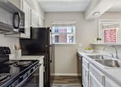 Thumbnail 14 of 26 - Kitchen with black appliances at The Hamptons, Dallas, TX
