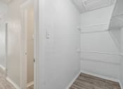 Thumbnail 63 of 68 - A walk-in closet of our A7 apartment The Escapade with white walls and wood flooring at The Escapade, San Antonio, 78216