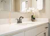 Thumbnail 13 of 41 - a bathroom with a sink and a mirror and a vase with flowers at Aero White Rock, Texas, 75238