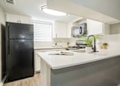 Thumbnail 3 of 41 - a kitchen with a white counter top and a black refrigerator at Aero White Rock, Dallas, Texas