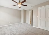 Thumbnail 9 of 19 - A room with a ceiling fan and carpeted floor at Knoll Crest, San Antonio, Texas 78240