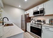 Thumbnail 21 of 54 - a kitchen with white cabinets and stainless steel appliances at The Frederick, San Antonio, 78240