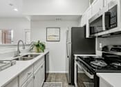 Thumbnail 2 of 40 - A modern kitchen with a black refrigerator and stove.