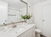 Thumbnail 12 of 40 - A bathroom with a white sink and a mirror.