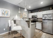 Thumbnail 20 of 40 - A kitchen with a white chair and a marble counter.