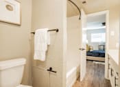 Thumbnail 14 of 41 - a bathroom with a white toilet and a tub and a shower at Aero White Rock, Dallas, TX