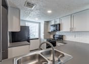 Thumbnail 35 of 45 - a kitchen with white cabinets and stainless steel appliances at Tradewinds, Texas