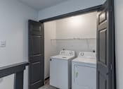 Thumbnail 37 of 45 - a laundry room with two washing machines and a door to a closet  at Tradewinds, Windcrest, TX, 78239
