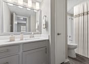 Thumbnail 21 of 22 - A bathroom with a white sink and a mirror above it.