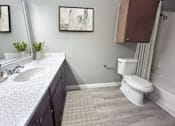 Thumbnail 27 of 28 - A bathroom with a white sink and a white toilet.