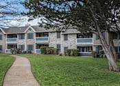 Thumbnail 12 of 38 - exterior view of an apartment building with a sidewalk at Polo Clubs Apartments, Austin