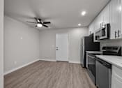 Thumbnail 62 of 79 - the living room of a home with a kitchen and a ceiling fan at Sunset Heights, San Antonio, TX, 78209