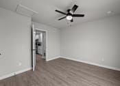 Thumbnail 65 of 79 - an empty living room with a ceiling fan and a door to a kitchen at Sunset Heights, San Antonio, TX