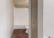 Thumbnail 34 of 47 - A white toilet sits in a small bathroom.