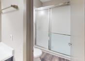 Thumbnail 47 of 47 - A bathroom with a white sink and a glass shower door.