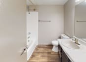 Thumbnail 46 of 47 - A bathroom with a white sink, toilet, and a white door.