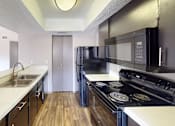 Thumbnail 39 of 47 - A kitchen with black appliances and white countertops.