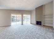 Thumbnail 36 of 47 - A spacious living room with a fireplace and sliding glass doors.