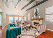 Thumbnail 13 of 20 - A living room with a green velvet sofa and a fireplace.
