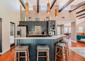 Thumbnail 14 of 20 - A kitchen with a bar and stools.