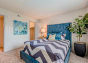 Thumbnail 7 of 20 - A bedroom with a large bed and a potted plant.