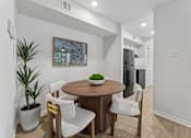Thumbnail 2 of 20 - Dining area with round wood table and chairs at Knoll Crest Apartments, San Antonio, Texas