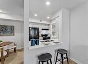 Thumbnail 3 of 20 - Modern kitchen with white cabinets and breakfast bar at Knoll Crest Apartments, Texas, 78240