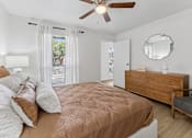 Thumbnail 9 of 20 - Bedroom with wood dresser and ceiling fan at Knoll Crest Apartments, San Antonio, TX