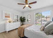 Thumbnail 7 of 20 - Bedroom with ceiling fan and large window at Knoll Crest Apartments, San Antonio, Texas