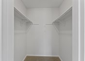 Thumbnail 43 of 47 - a walk in closet in a bedroom with white walls at The Hudson, North Richland Hills, TX