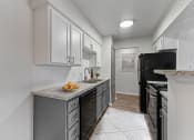 Thumbnail 2 of 50 - a kitchen with white cabinets and black appliances at The Hills at Ironhorse, North Richland Hills, Texas