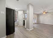 Thumbnail 19 of 38 - an empty living room and kitchen with a ceiling fan at Polo Clubs Apartments, Austin, 78729