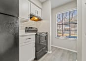 Thumbnail 14 of 38 - a kitchen with a stove and refrigerator and a window at Polo Clubs Apartments, Texas, 78729