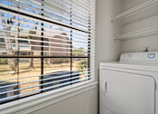 Thumbnail 24 of 38 - a laundry room with a washer and dryer next to a window at Polo Clubs Apartments, Austin