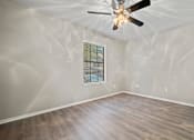 Thumbnail 20 of 38 - an empty bedroom with a ceiling fan and a window at Polo Clubs Apartments, Texas