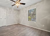 Thumbnail 26 of 38 - an empty bedroom with a ceiling fan and a window at Polo Clubs Apartments, Austin, 78729