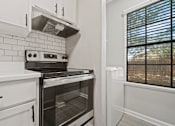 Thumbnail 28 of 38 - kitchen with a stove and a window at Polo Clubs Apartments, Texas, 78729