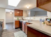 Thumbnail 12 of 21 - Kitchen with wooden cabinets at Amberly Village Townhomes, Texas, 75040