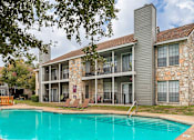 Thumbnail 3 of 24 - our apartments offer a swimming pool and a patio with lounge chairs at The Broadwater at Salado Creek, San Antonio, TX