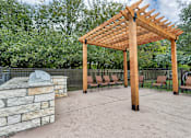 Thumbnail 6 of 24 - a patio with a stone fireplace and a wooden pavilion at The Broadwater at Salado Creek, San Antonio