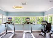 Thumbnail 4 of 38 - two exercise bikes in a workout room with windows at Polo Clubs Apartments, Texas